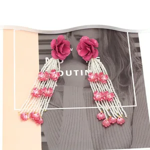 Détails des boucles d'oreilles florales faites main avec perles roses et pompons
