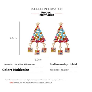 Détail de boucles d'oreilles sapin de Noël avec strass colorés et boîtes cadeaux