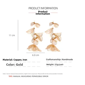 Detail of handmade gold leaf drop earrings featuring layered copper and iron mesh texture