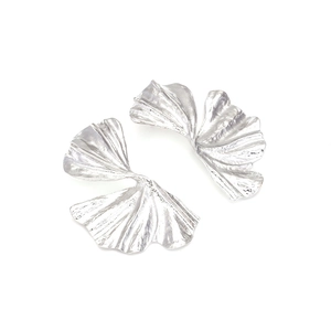 Macro shot of silver ginkgo leaf earrings featuring natural radial textured metal details