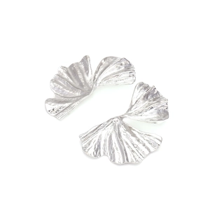 Macro view of silver ginkgo leaf earrings showing detailed radial pleated textures