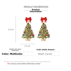 Vue détaillée des boucles d'oreilles sapin de Noël avec dimensions 5,6cm x 3,2cm et nœud rouge