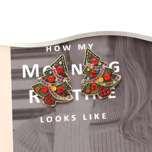 Christmas tree earrings with colorful rhinestones and green enamel on fashion magazine