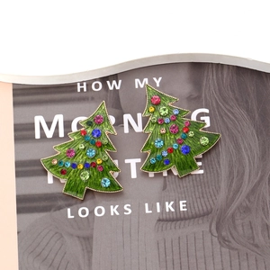 Détail des boucles d'oreilles sapin de Noël en émail avec strass colorés et bordure dorée