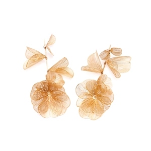 Detail of gold floral earrings with woven mesh petals and long leaf drops on white background