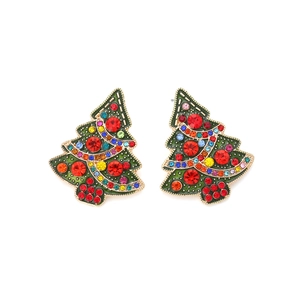 Detailed macro view of Christmas tree earrings with colorful rhinestones and gold trim