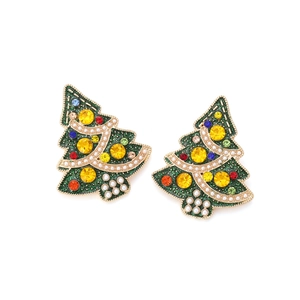 Detail of Christmas tree earrings with colorful rhinestones and white pearls on gold alloy