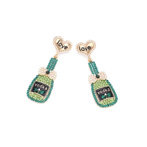 Détail des boucles d'oreilles bouteille de vodka avec strass verts et nœud perle