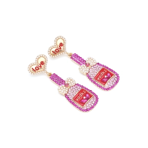 Détail de boucles d'oreilles cœur avec perles et pendentifs bouteille de vodka rose