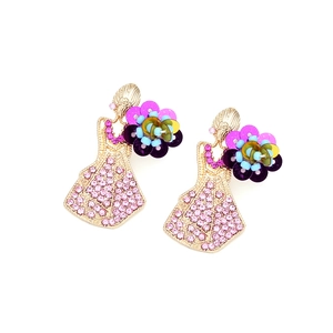 Dettaglio di orecchini a forma di donna con strass rosa e petali di fiori in acrilico