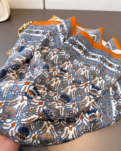 Detail of bohemian floral silk scarf in blue and orange on a vintage gold tray