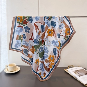 Floral imitation silk scarf with blue tulip and orange wildflower print hanging elegantly