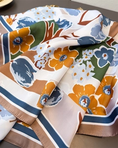 Detailed close-up showing soft silky texture and abstract floral pattern of the scarf