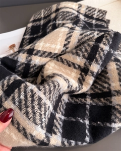 Gros plan d'une écharpe à carreaux épaisse avec une texture brossée et des franges