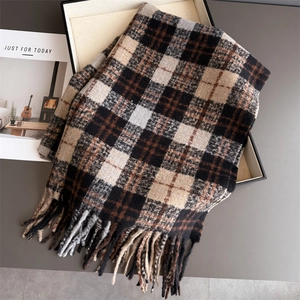 Détail de la texture du foulard à carreaux avec pompons et tissu effet cachemire