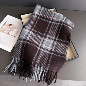 Détail d'une écharpe à carreaux vintage avec franges dans un coffret cadeau chic