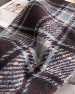 Gros plan sur un tissu en maille à carreaux épais montrant les détails marron et bleus
