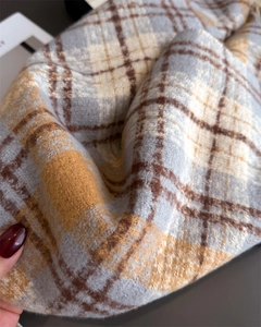 Gros plan sur le tissu doux de l'écharpe à carreaux montrant la texture pelucheuse