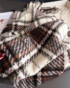 Gros plan d'une écharpe à carreaux épaisse avec franges en marron, olive et beige