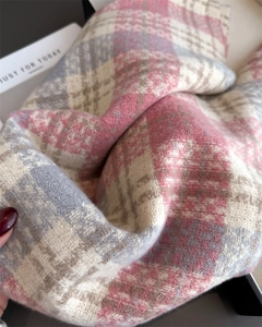 Détail de la texture d'écharpe en maille à carreaux avec franges douces roses et bleues