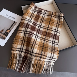 Gros plan d'une écharpe à carreaux marron et beige avec franges épaisses et texture laine