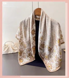 Close-up of silk scarf with brown and ginger floral print on a wooden hanger