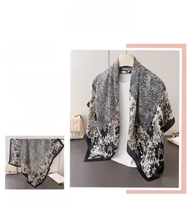 Detail view of a large floral silk-feel scarf with black and white patterns and dots
