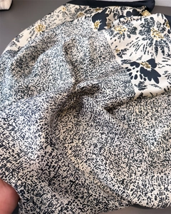 Detailed macro view of abstract floral silk scarf featuring satin texture and hand-rolled edges