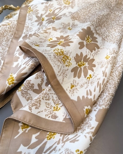 Detail of silk scarf with brown daisy print showing smooth texture and edge stitching