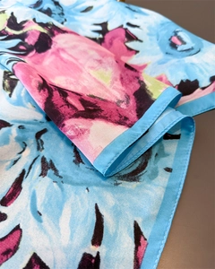 Détail de la texture soyeuse et des coutures fines sur le foulard en soie imprimé