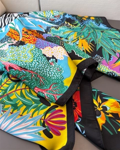 Close-up of zebra print silk scarf showing tropical leaves and soft satin texture