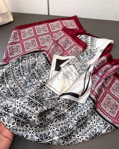 Detailed close-up of luxurious zebra print silk scarf with geometric floral patterns
