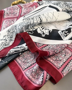 Detail of silk scarf showing zebra print, city sketch patterns and vibrant red border