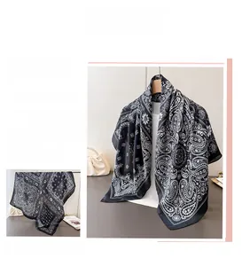 Detail of classic paisley pattern on black and white silk scarf with soft drape