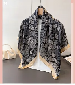 Detail eines Satin-Paisley-Schals mit Goldrand an einem klassischen Holzkleiderbügel