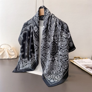 Classic black and white paisley print large silk scarf shown draped on a hanger