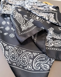 Detail of vintage paisley silk scarf featuring black and white cross logo pattern