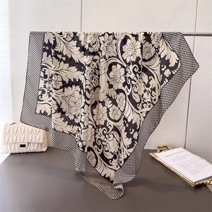 Eleganter schwarz-weißer Seidenschal mit Blumenmuster und gepunkteter Kante im Display