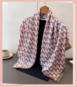 Detail of pink satin scarf with geometric pattern draped on a wooden hanger