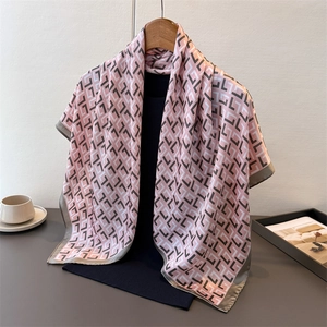 Detail of elegant satin scarf with vintage geometric pattern hanging on a wooden hanger