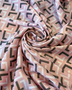Detailed view of pink satin scarf texture with elegant black geometric monogram patterns