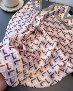 Detail of pink satin scarf with vintage geometric print and smooth silk texture