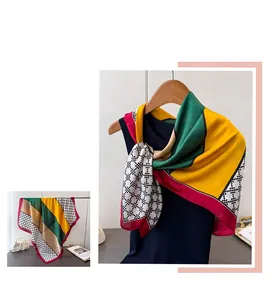 Detail of elegant satin scarf showing bright geometric color blocks and houndstooth patterns