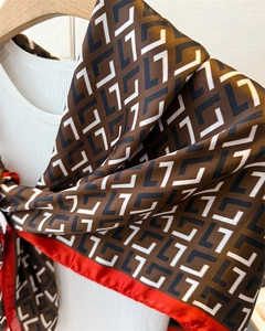 Detailed view of vintage silk scarf featuring geometric L-pattern with elegant red border