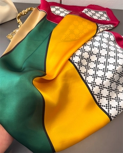 Close-up of luxury satin scarf featuring geometric patchwork and elegant silk texture