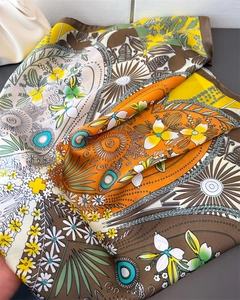 Detail of silk-feel scarf featuring artistic clover prints and refined rolled edges