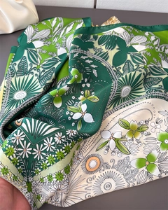 Detailed macro view of green clover silk scarf featuring delicate floral and leaf patterns