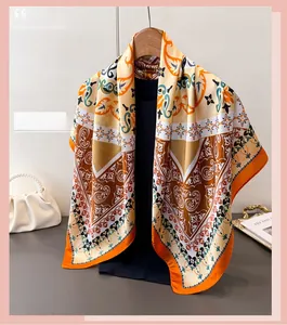 Detail of elegant silk-like scarf with vintage paisley pattern hanging on a wooden hanger