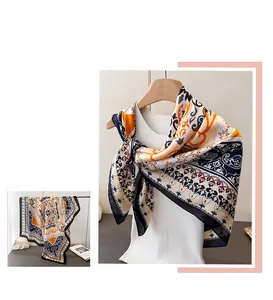 Detailed view of bohemian floral patterns and silk texture on a navy blue square scarf