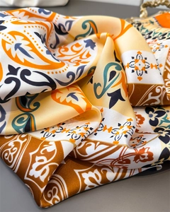 Detail of silk satin scarf showing vibrant paisley prints and luxurious draped texture